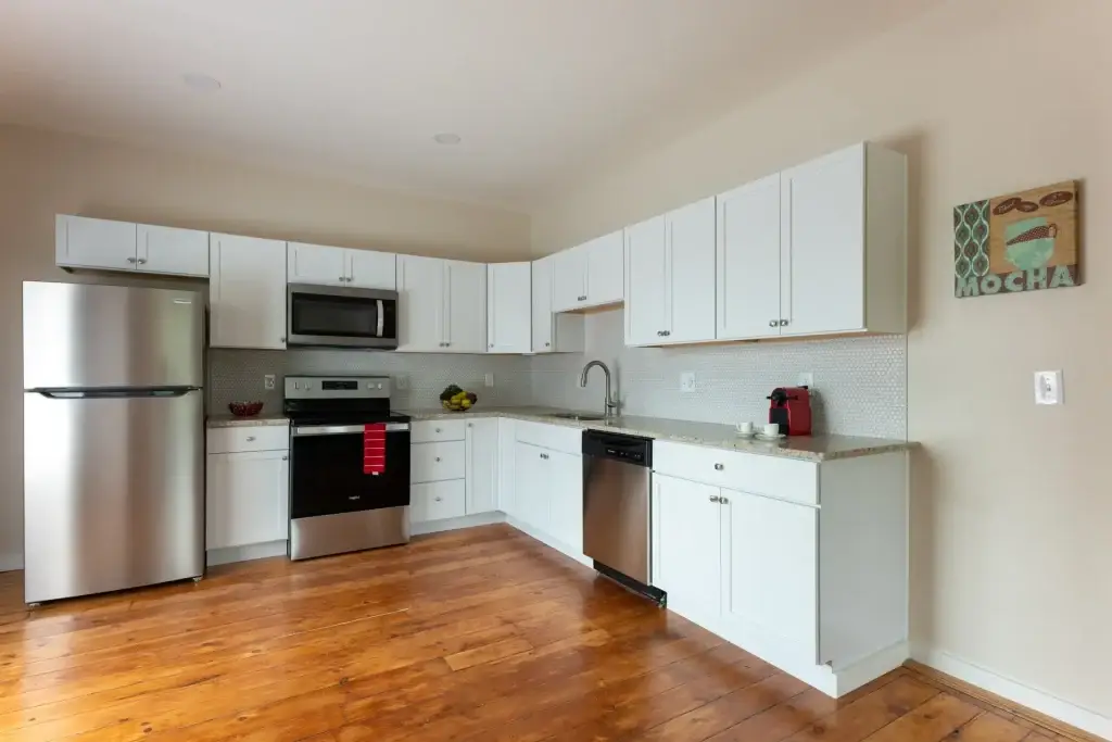 Renovated kitchen with white cabinetry and stainless-steel appliances at Hazelwood Avenue in Piety Hill, Detroit
